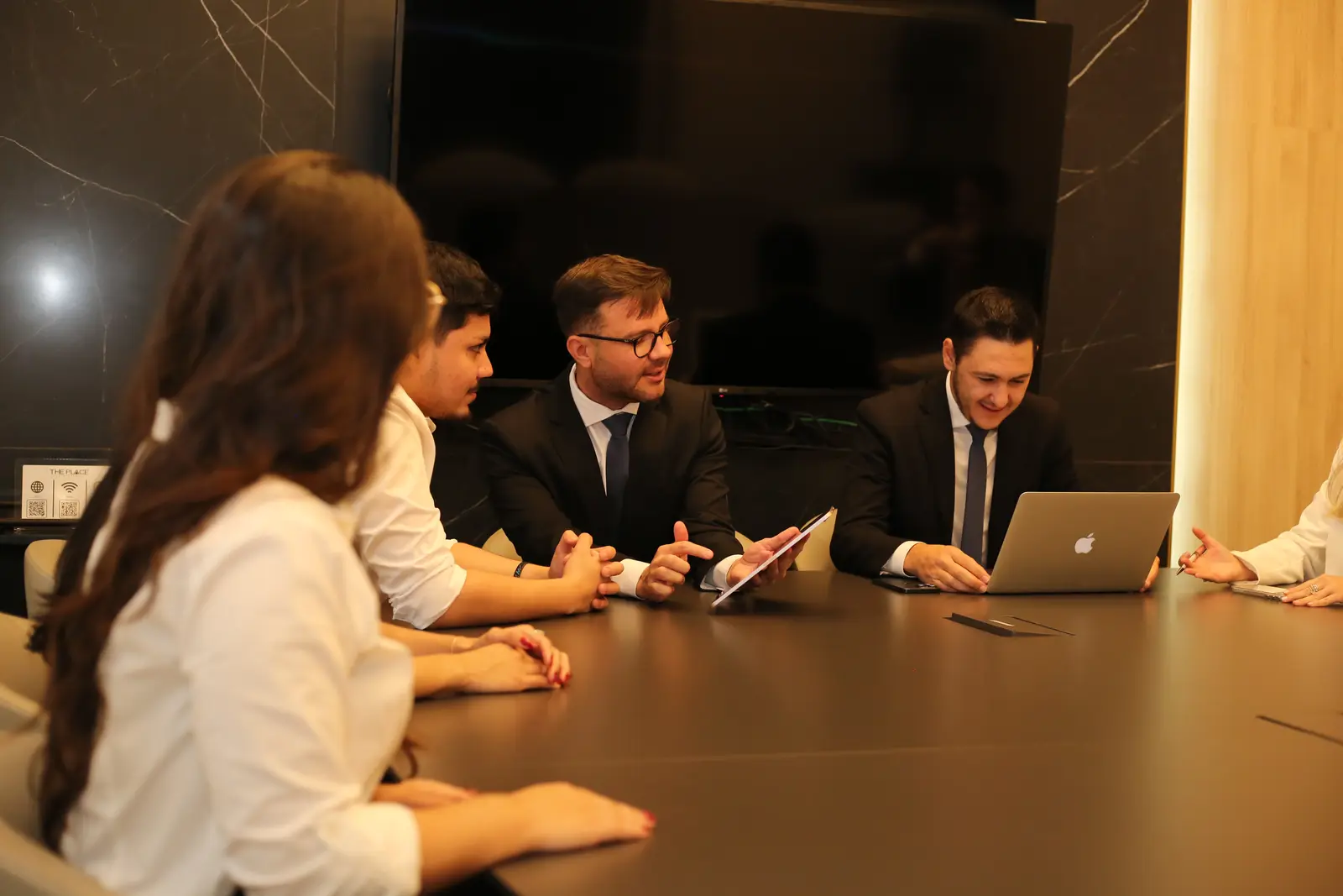 Os sócios em reunião com a equipe na sala de reuniões